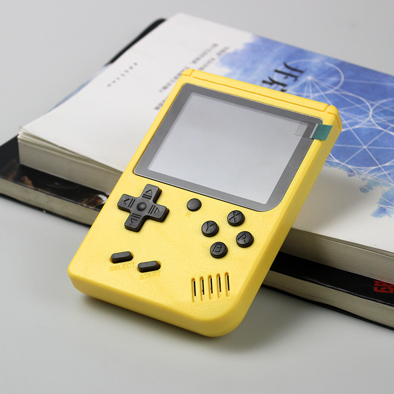 yellow handheld game console on books