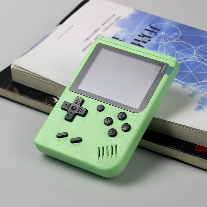 light green handheld gaming device on books