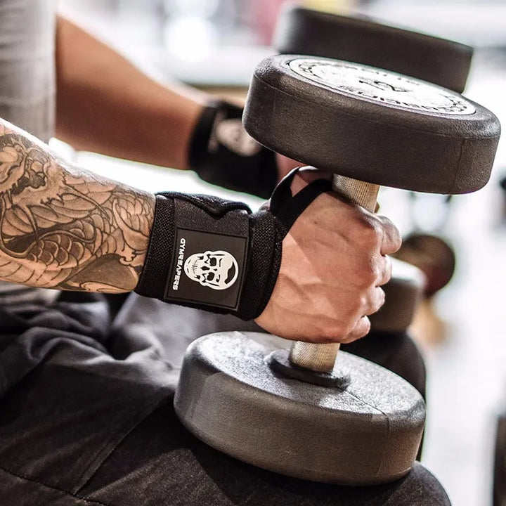 Athlete adjusting GymReapers wrist wraps – black compression wrap with skull patch for bench press and strength training